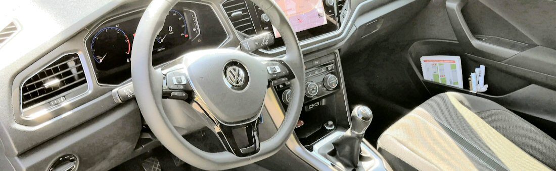 Het interieur van de lesauto van Autorijschool Thea, met stuur, dashboard en versnellingspook.