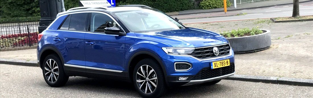 De lesauto van Autorijschool Thea langs de weg, met geel Nederlands kenteken.